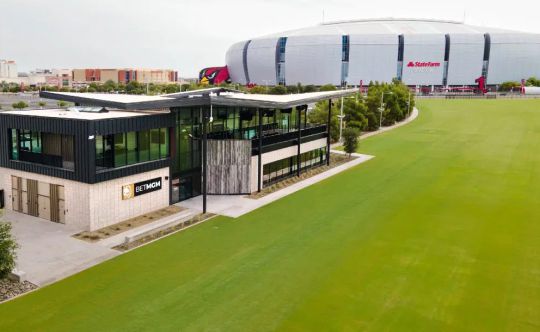 Modern building and lawn in front of a domed stadium