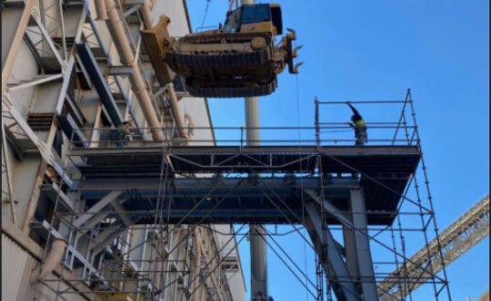 Steel frame and platforms with a crane hook against a blue sky