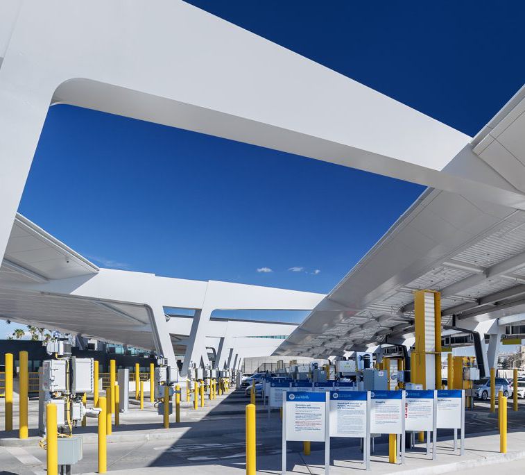 Looking up at a white steel canopy over a row of gates