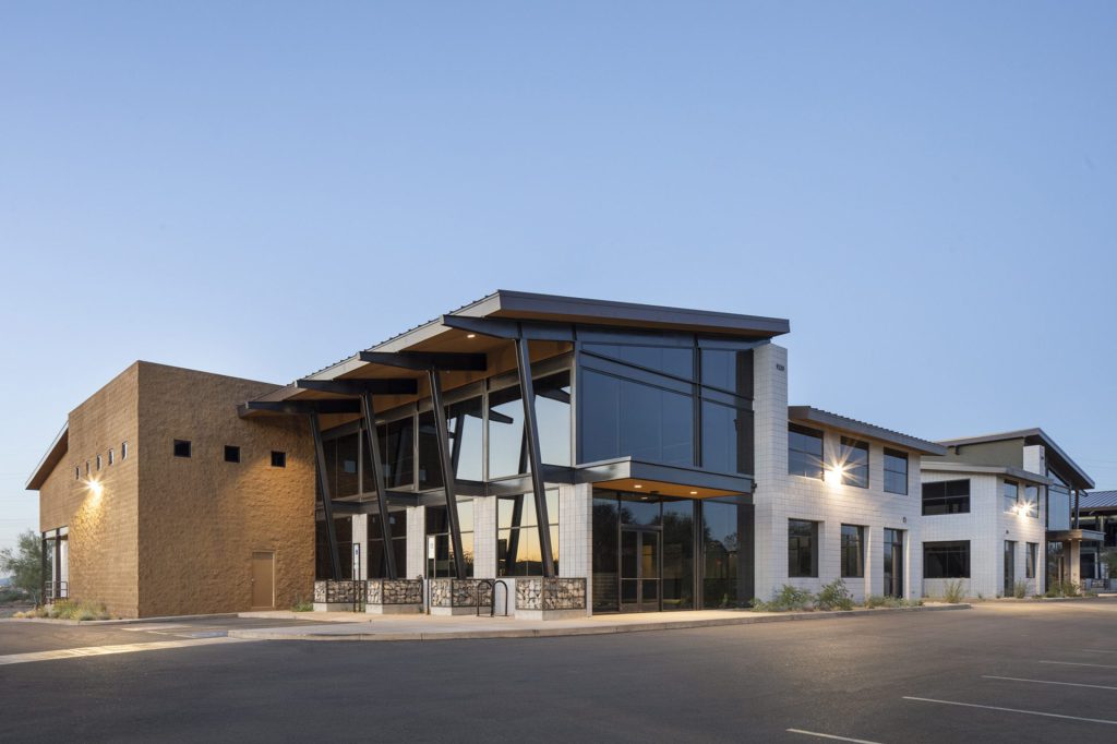 Two-storey building with a steel canopy at dusk